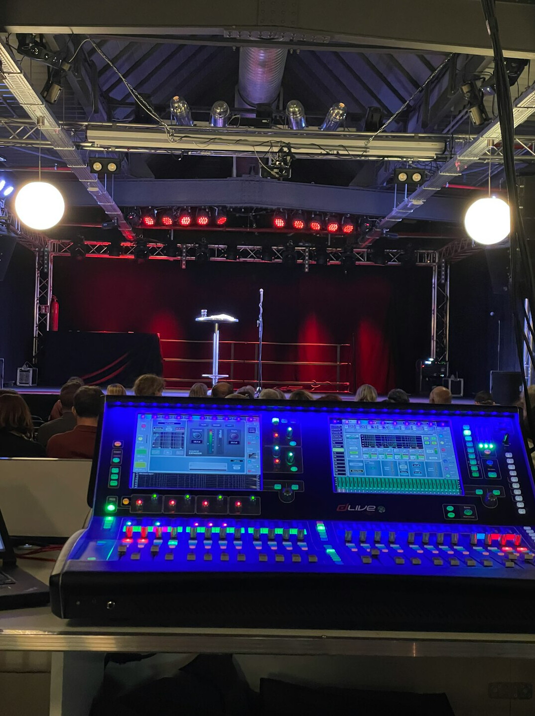 Television broadcast control room with multiple monitors and a vision mixing desk